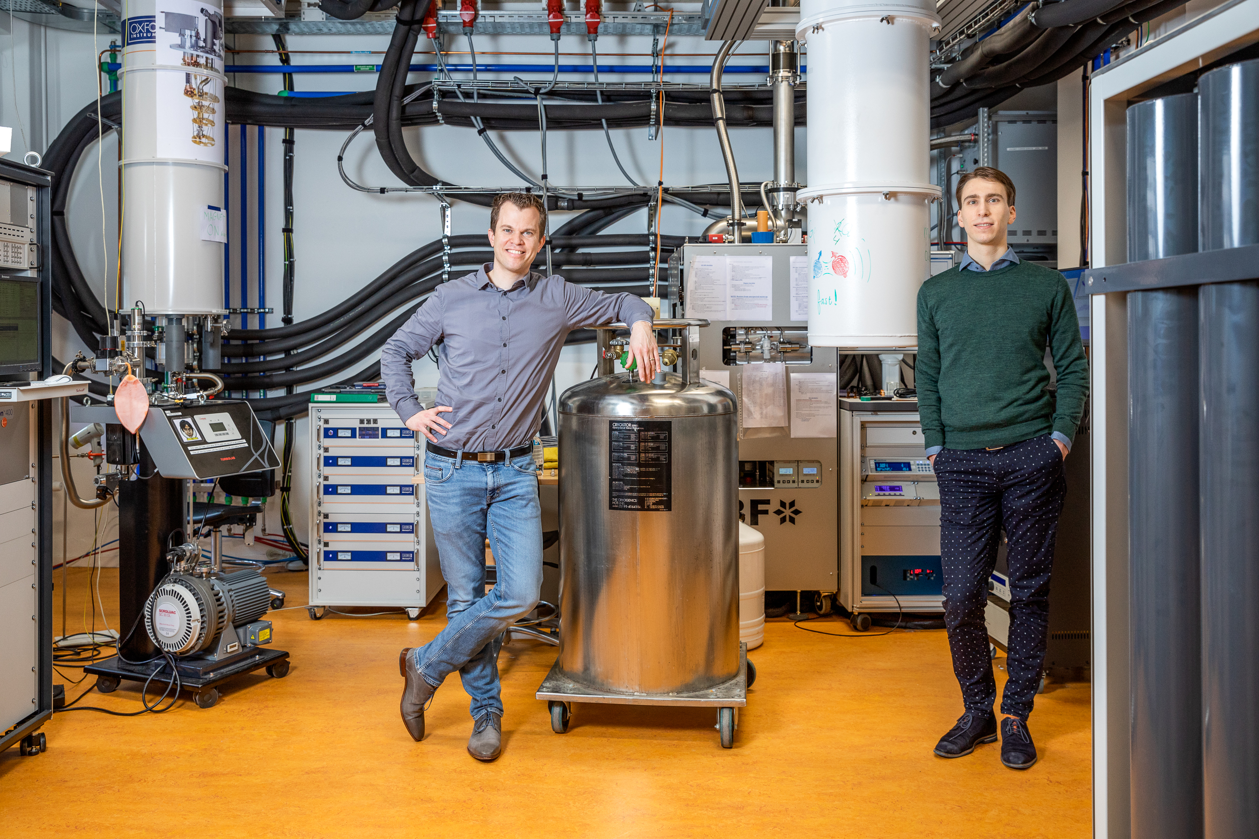 Menno Veldhorst en Nico Hendrickx naast hun opstelling met daarin de germanium quantumprocessor.